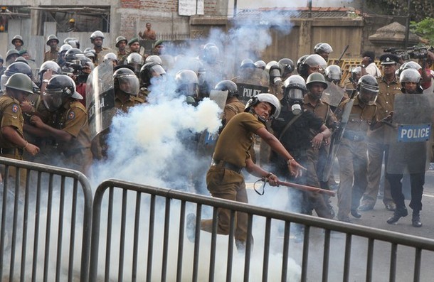 Sri Lankan policemen in riot gear fire t